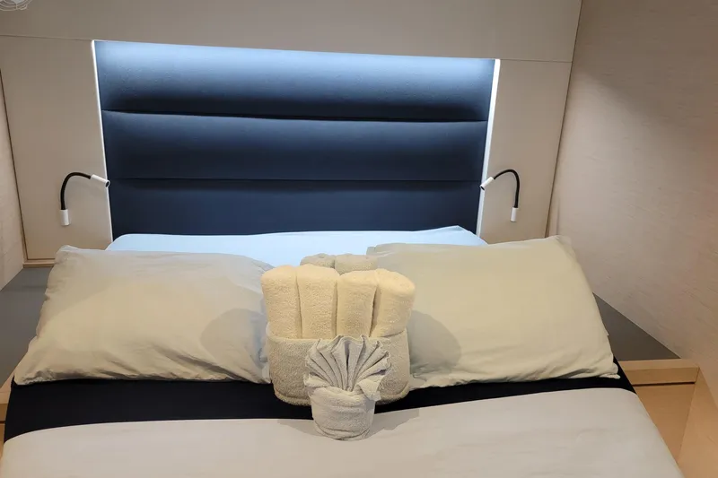 Three Sheets Yacht Photos Pics Luxurious cabin bed with folded towels on a 2019 Fountaine Pajot Saona 47 yacht.