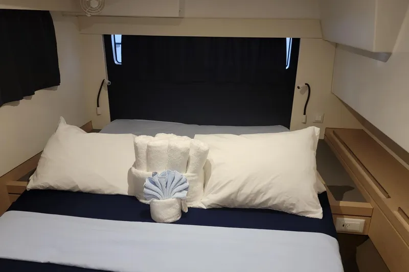 Three Sheets Yacht Photos Pics Luxurious cabin interior of 2019 Fountaine Pajot Saona 47 with neatly arranged towels.