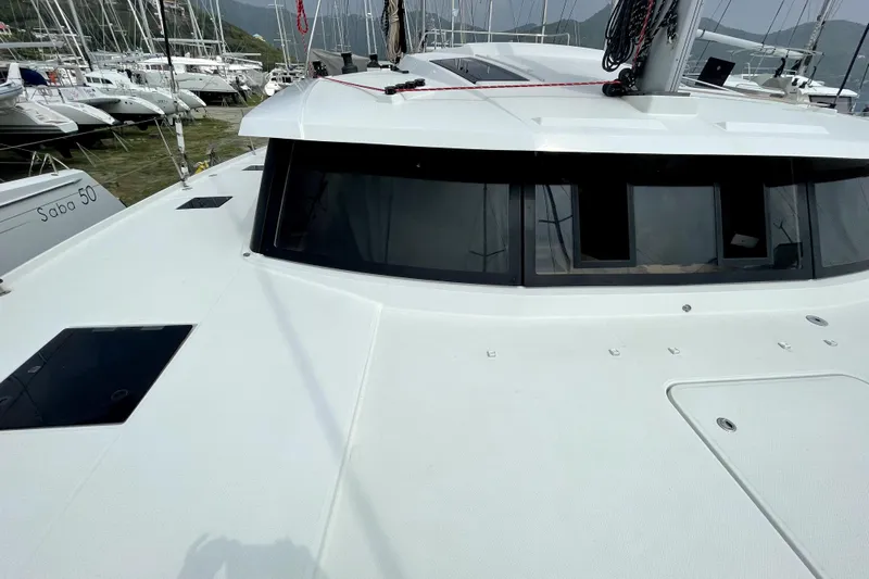 Three Sheets Yacht Photos Pics 2019 Fountaine Pajot Saona 47 catamaran docked in a marina, showcasing sleek design and windows.