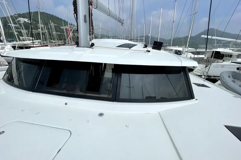 Three Sheets Yacht Photos Pics 2019 Fountaine Pajot Saona 47 catamaran docked in a marina, showcasing sleek design and windows.