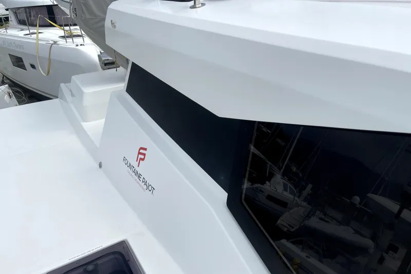 Three Sheets Yacht Photos Pics 2019 Fountaine Pajot Saona 47 catamaran, sleek design with logo, docked at marina.