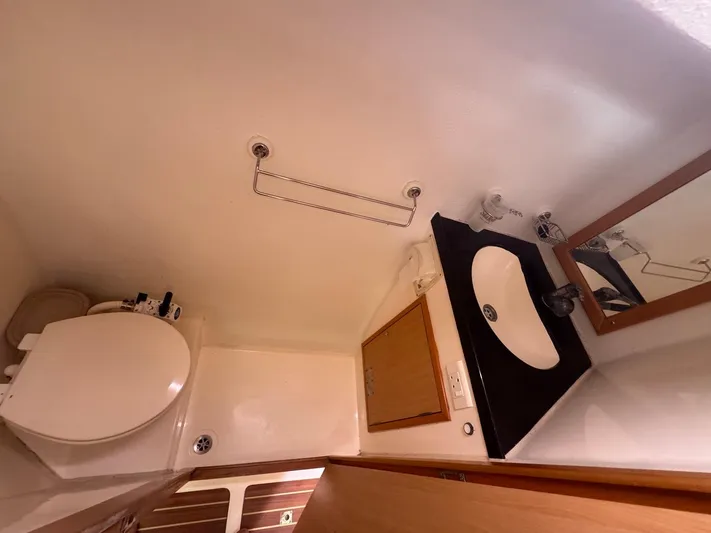 Avatar Yacht Photos Pics Compact bathroom in 2010 Admiral 38 Executive yacht with sink, mirror, and toilet.