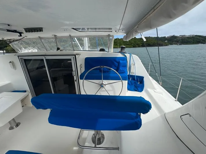 Avatar Yacht Photos Pics 2010 Admiral 38 Executive yacht with blue seating and steering wheel, docked by the water.