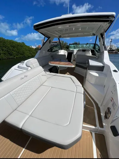 2023 Sea Ray Sundancer 320 @ Cancun Yacht Photos Pics 2023 Sea Ray Sundancer 320 yacht interior with luxurious seating and table, under clear blue sky.