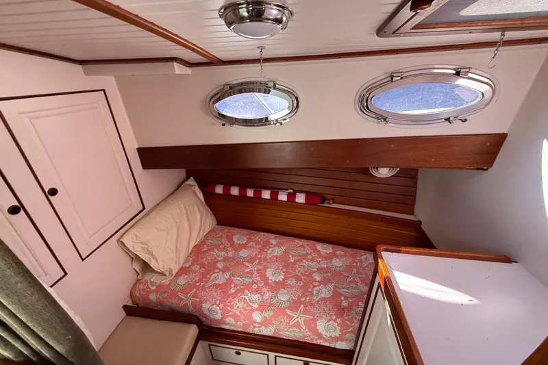  Yacht Photos Pics Cozy cabin interior of 2006 Mast & Mallet Thomas Point 40 boat with portholes and bed.