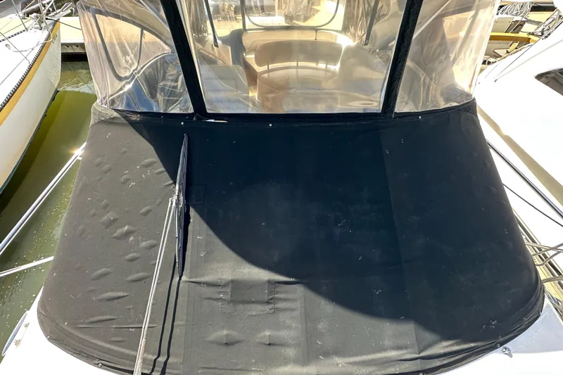 Beyond The Reef Yacht Photos Pics 2008 Regal Commodore 4060 boat with black cover and clear enclosure in marina.