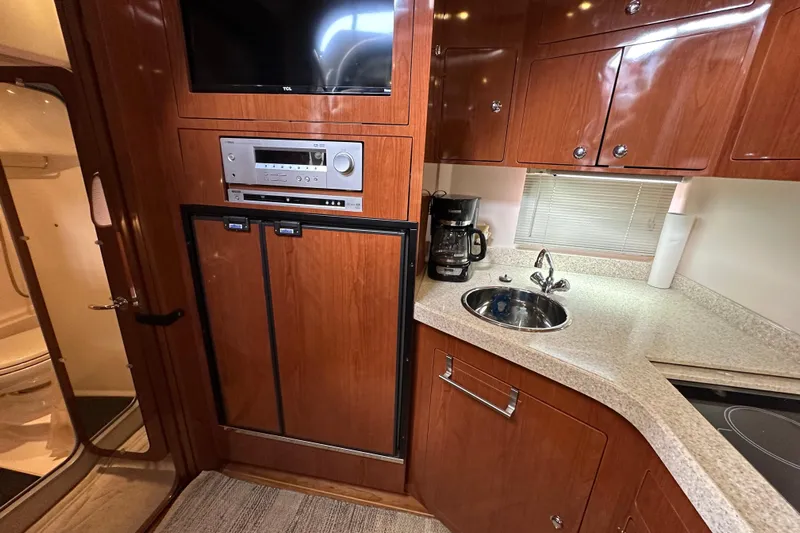 Beyond The Reef Yacht Photos Pics 2008 Regal Commodore 4060 yacht kitchen with wood cabinets, sink, and appliances.