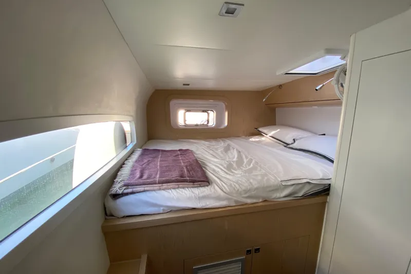 Inky Blue Yacht Photos Pics Cozy cabin interior of 2018 Outremer 51 yacht with bed and window view.