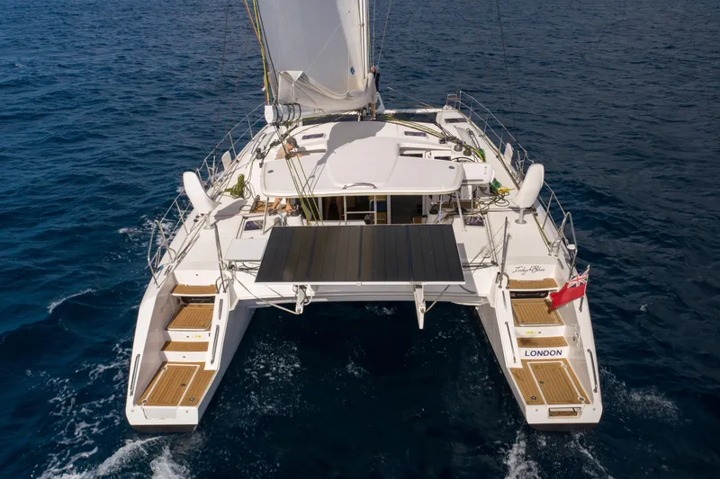 Inky Blue Yacht Photos Pics 2020 Outremer 51 catamaran sailing on open sea, rear view.
