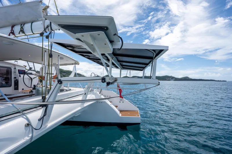 Inky Blue Yacht Photos Pics Outremer 51 catamaran (2020) with solar panels, sailing on a clear blue sea.