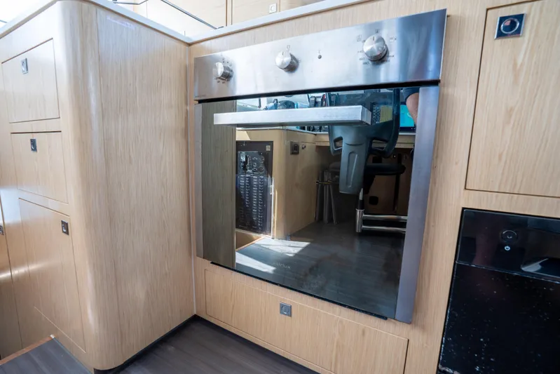 Inky Blue Yacht Photos Pics Modern kitchen interior of 2020 Outremer 51 yacht with sleek wooden cabinetry.