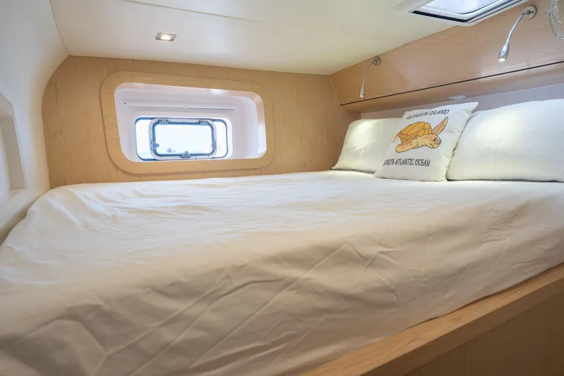 Inky Blue Yacht Photos Pics Cozy bedroom interior of 2020 Outremer 51 yacht with nautical-themed pillow.