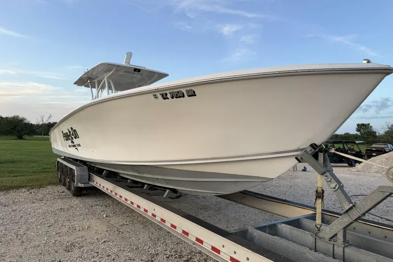 Pass It On Yacht Photos Pics 2014 SeaHunter 40 Tournament boat on trailer, parked on gravel with grassy background.