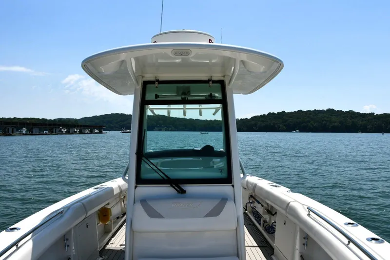  Yacht Photos Pics 2016 Boston Whaler 280 Outrage boat on a serene lake with distant shoreline.