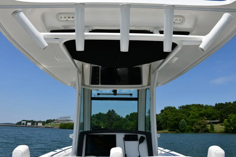  Yacht Photos Pics Boston Whaler 280 Outrage 2016 boat console with rod holders, on a sunny day.