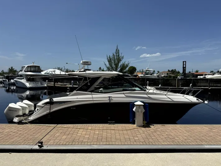 Salty Xperience Yacht Photos Pics 2020 Sea Ray 320 Sundancer OB Coupe docked at marina under clear blue sky.