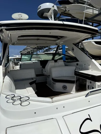 Salty Xperience Yacht Photos Pics 2020 Sea Ray 320 Sundancer OB Coupe interior with seating and helm, docked under clear sky.