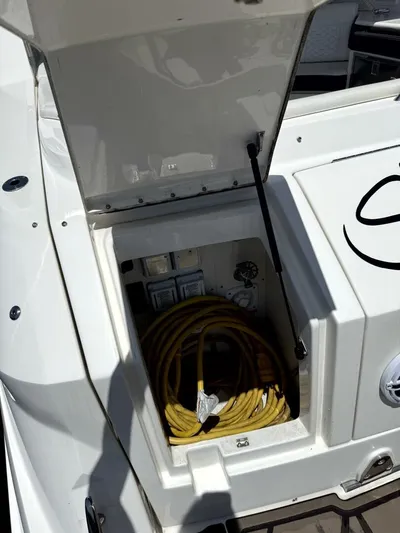 Salty Xperience Yacht Photos Pics Open storage compartment on 2020 Sea Ray 320 Sundancer OB Coupe with coiled yellow hose.