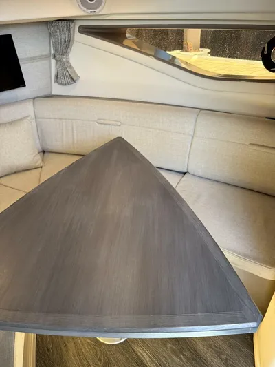 Salty Xperience Yacht Photos Pics Interior of 2020 Sea Ray 320 Sundancer OB Coupe with triangular table and cushioned seating.