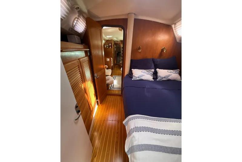 Spellbound Yacht Photos Pics Cozy interior of 2000 Catalina 470 yacht with wooden finishes and blue bedding.