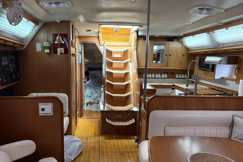 Spellbound Yacht Photos Pics Interior of a 2000 Catalina 470 yacht with wooden finishes and cozy seating area.