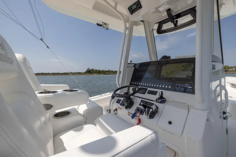 Big D Yacht Photos Pics 2021 Regulator 28FS boat cockpit with modern controls and seating, on a sunny day.