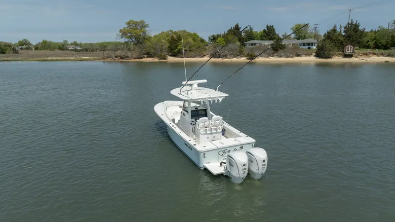Big D Yacht Photos Pics 2021 Regulator 28FS boat on calm water near a shoreline.
