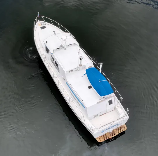 Harmony Yacht Photos Pics Aerial view of a 1980 Custom TRI CABIN boat with a blue canopy.