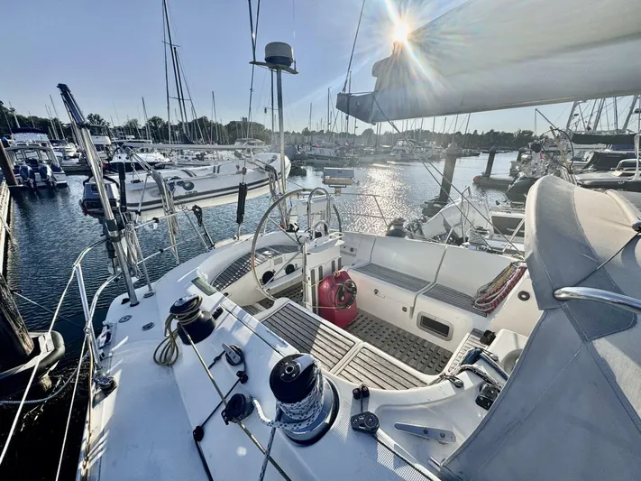  Yacht Photos Pics Cockpit view of a 1991 Beneteau 45 First sailboat docked in a sunny marina.