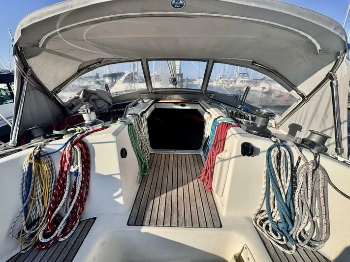  Yacht Photos Pics Cockpit of 1991 Beneteau 45 First sailboat with colorful ropes and canopy.