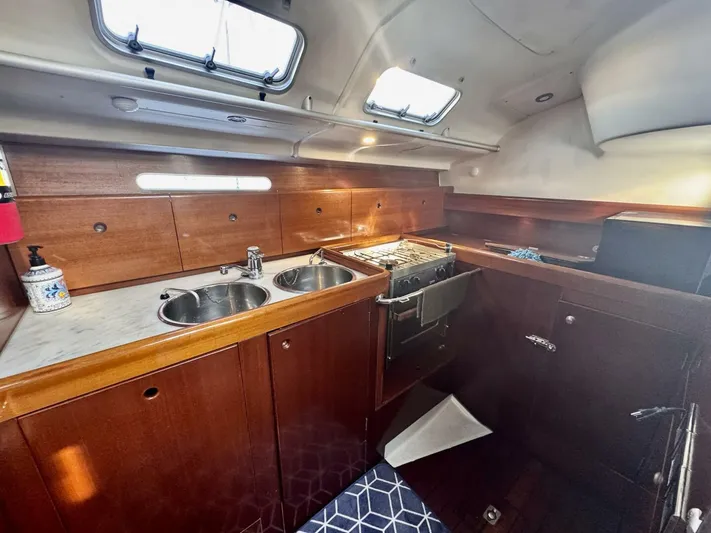  Yacht Photos Pics Interior of 1991 Beneteau 45 First yacht kitchen with wood cabinetry and dual sinks.