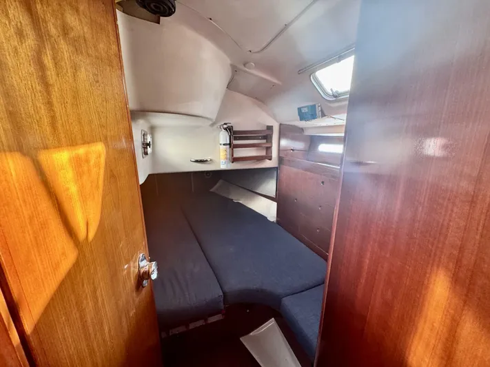  Yacht Photos Pics Interior cabin of 1991 Beneteau 45 First sailboat with wooden finish and cozy sleeping area.