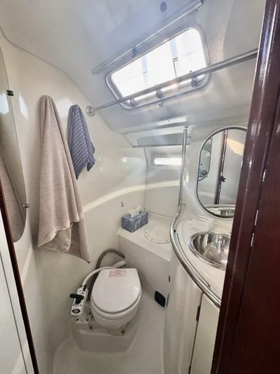  Yacht Photos Pics Bathroom interior of 1991 Beneteau 45 First yacht, featuring toilet, sink, and towels.