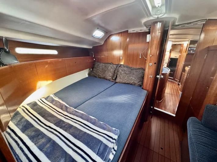 Yacht Photos Pics Cozy cabin interior of 1991 Beneteau 45 First sailboat with wooden finish and comfortable bedding.