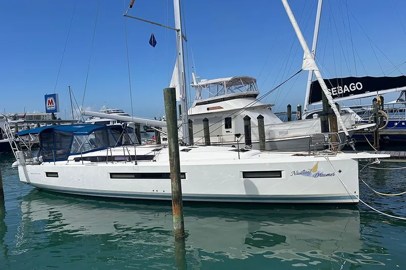 Nautical Dreamer Yacht Photos Pics 2019 Jeanneau Sun Odyssey 490 sailboat docked in a marina, clear blue sky.