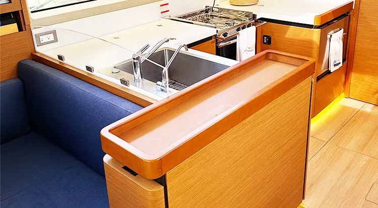 Nautical Dreamer Yacht Photos Pics Modern kitchen interior of 2019 Jeanneau Sun Odyssey 490 yacht, featuring sleek wood finishes.