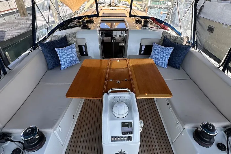 Nautical Dreamer Yacht Photos Pics 2019 Jeanneau Sun Odyssey 490 cockpit with wooden table and cushioned seating.