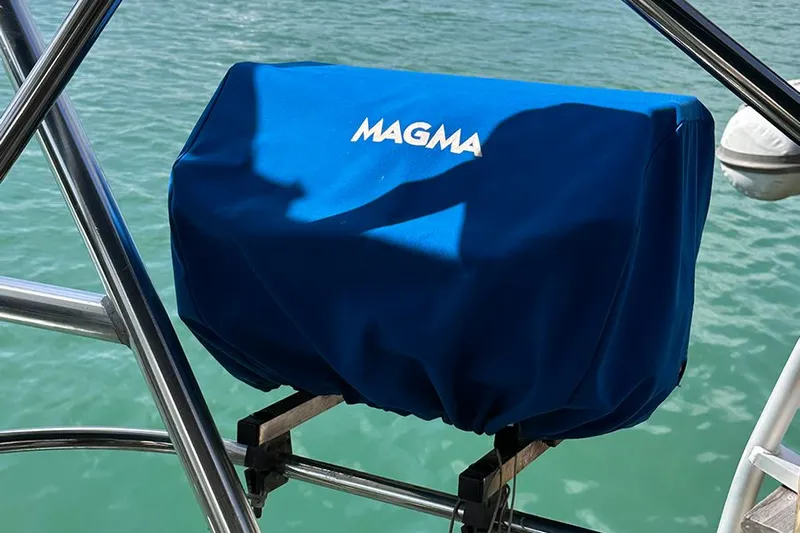 Nautical Dreamer Yacht Photos Pics Blue Magma grill cover on Jeanneau Sun Odyssey 490, 2019 model, near water.