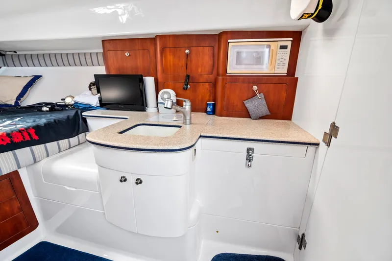 Pura Vita Yacht Photos Pics 2006 Intrepid 377 WA cabin interior with kitchenette, microwave, and bed.