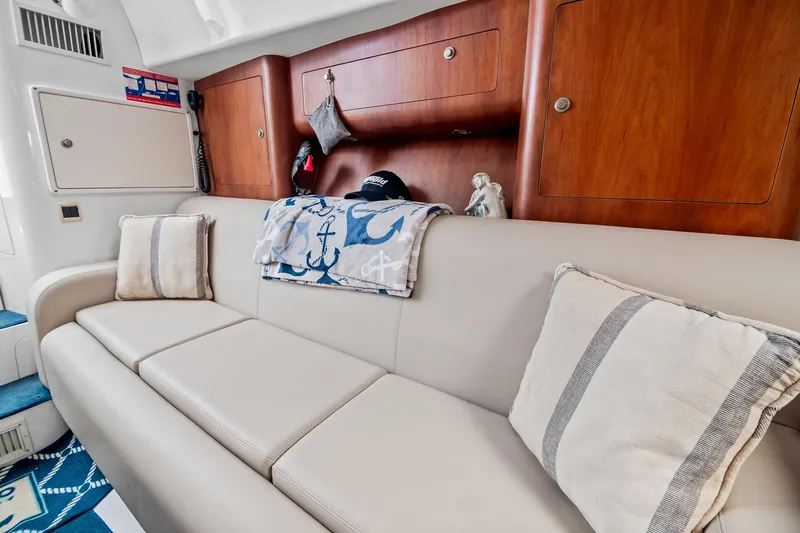 Pura Vita Yacht Photos Pics Interior of 2006 Intrepid 377 WA boat with beige sofa and nautical decor.