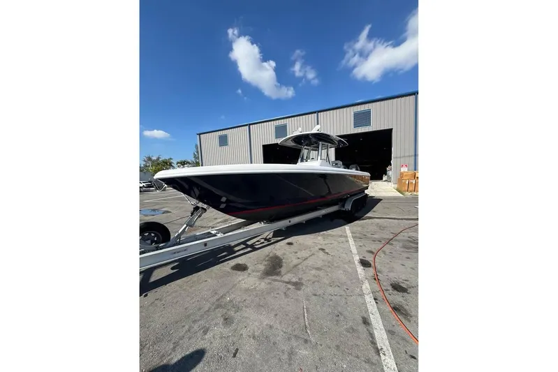  Yacht Photos Pics 2018 Intrepid 32 boat on trailer outside a warehouse under a clear blue sky.