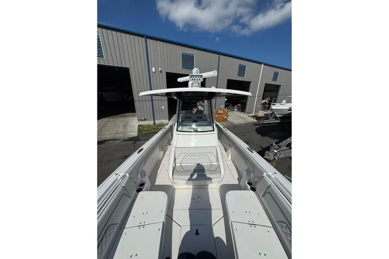 Yacht Photos Pics 2018 Intrepid 32 boat docked outside a warehouse under a clear blue sky.