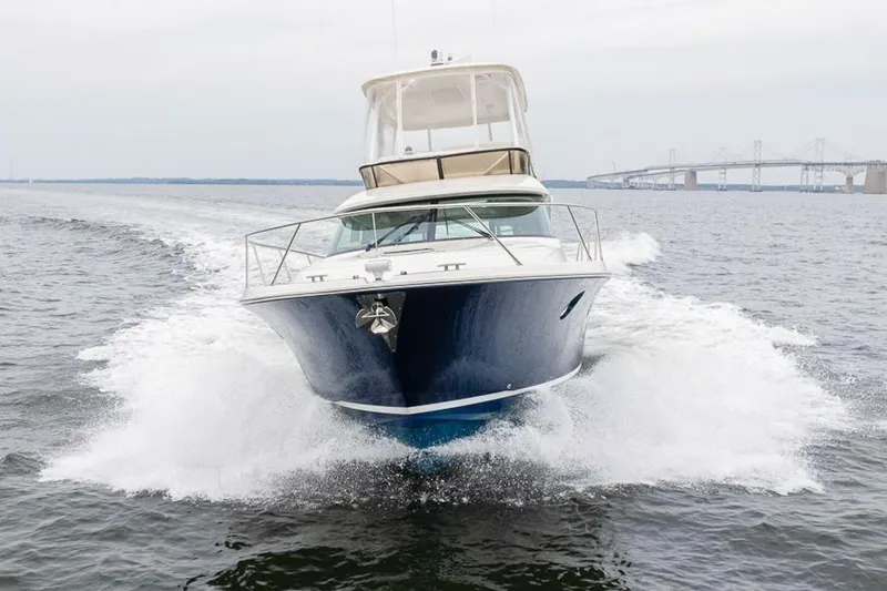  Yacht Photos Pics 2021 Tiara Yachts F44 Flybridge cruising on open water near a bridge.