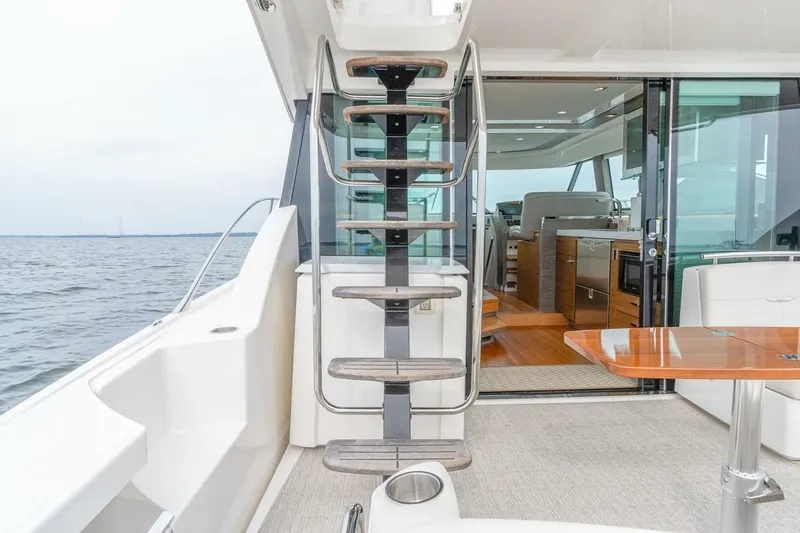  Yacht Photos Pics 2021 Tiara Yachts F44 Flybridge interior with staircase and ocean view.