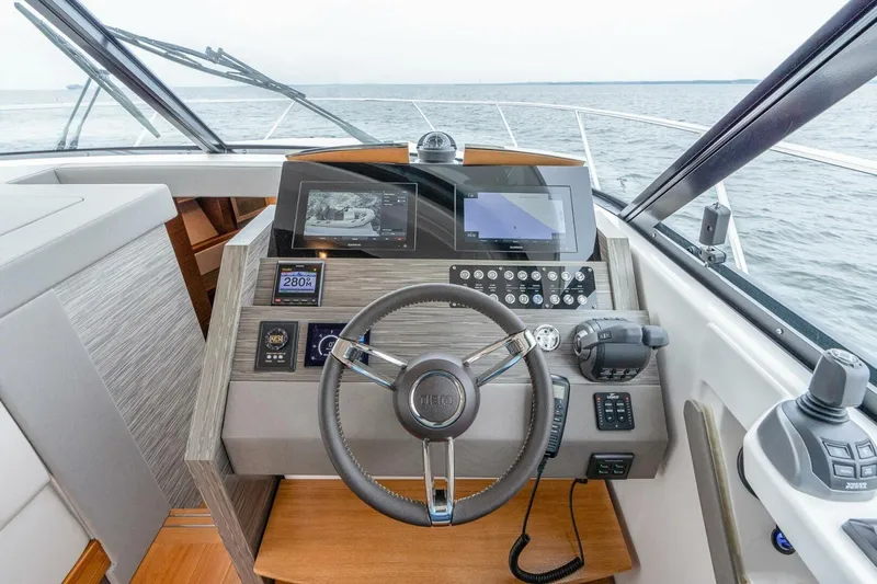  Yacht Photos Pics 2021 Tiara Yachts F44 Flybridge helm with modern navigation controls and steering wheel.