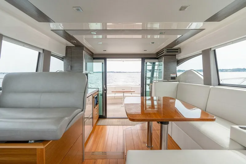  Yacht Photos Pics Interior of 2021 Tiara Yachts F44 Flybridge, featuring elegant seating and wooden table.