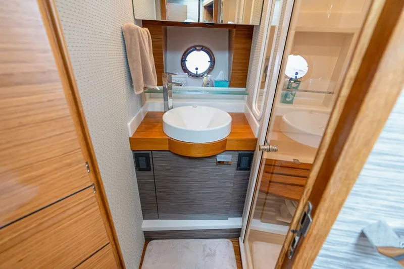 Yacht Photos Pics Luxurious bathroom in 2021 Tiara Yachts F44 Flybridge with modern sink and wooden accents.