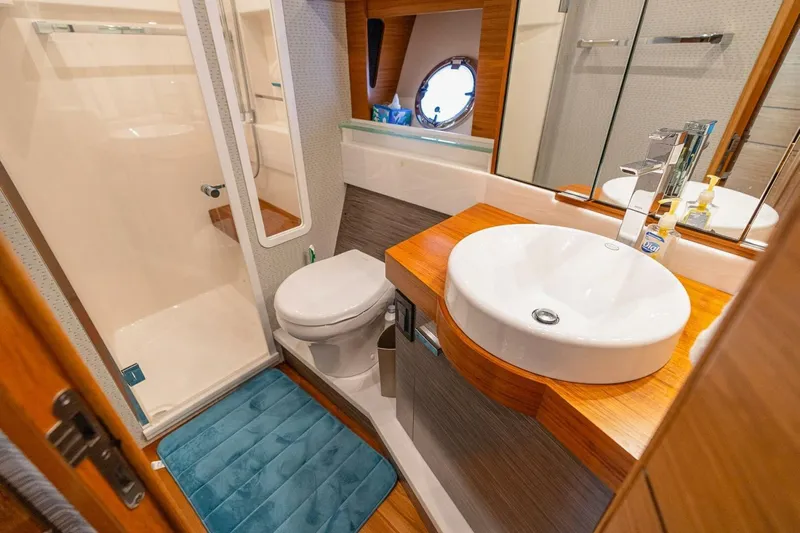 Yacht Photos Pics Luxurious bathroom in 2021 Tiara Yachts F44 Flybridge, featuring modern sink and shower.