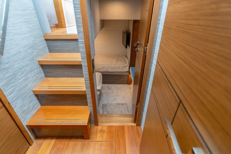  Yacht Photos Pics Interior of 2021 Tiara Yachts F44 Flybridge, featuring wooden stairs and cozy cabin.