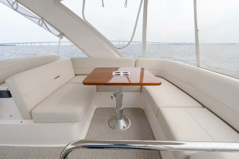  Yacht Photos Pics 2021 Tiara Yachts F44 Flybridge interior with elegant seating and wooden table.